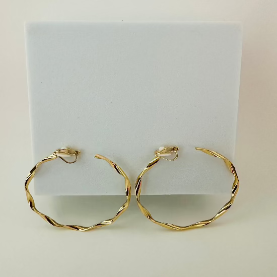 Close-up of sleek gold clip-on hoop earrings, featuring a timeless and comfortable design for non-pierced ears.
Let me know if there’s anything else you’d like to refine!