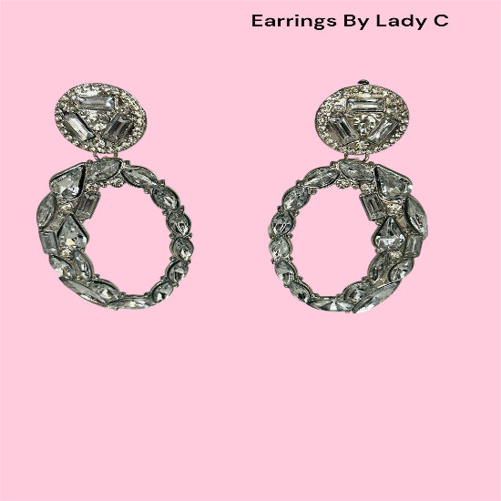 Pair of ornate earrings on a pink background with 'Earrings By Lady C' text.