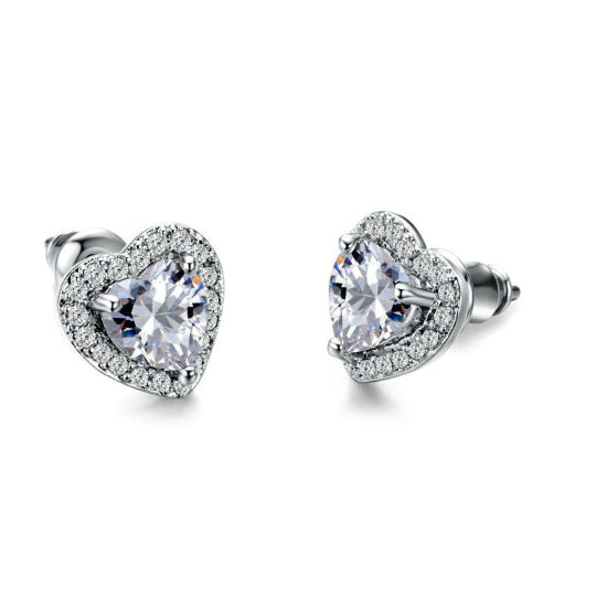 Heart-shaped stud earrings featuring sparkling white diamonds, elegantly set in a polished metal setting."