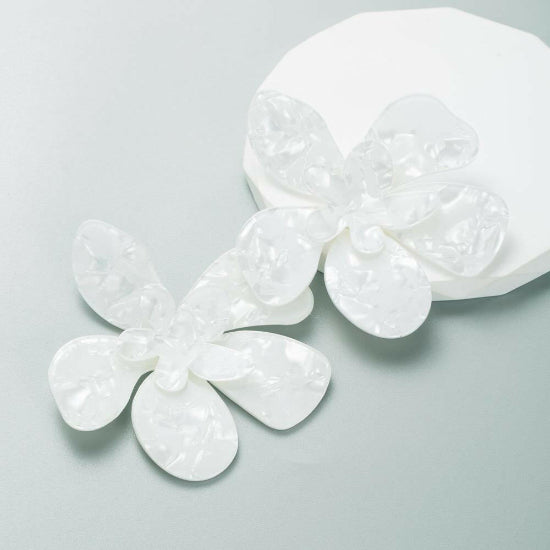 Large flower-shaped stud earrings in vibrant whit, featuring bold, detailed petals with a glossy finish.