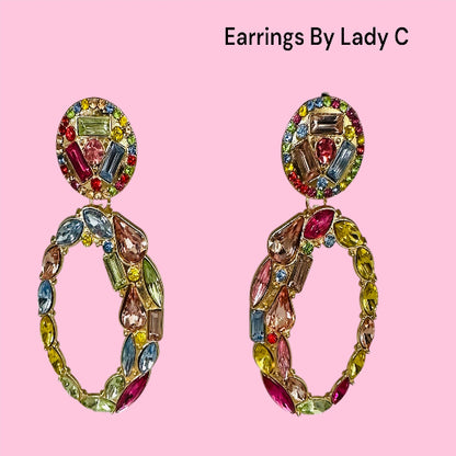 Colorful earrings with gemstones on a pink background, labeled 'Earrings By Lady C'.