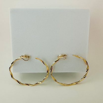 Close-up of sleek gold clip-on hoop earrings, featuring a timeless and comfortable design for non-pierced ears.

Let me know if there’s anything else you’d like to refine!






