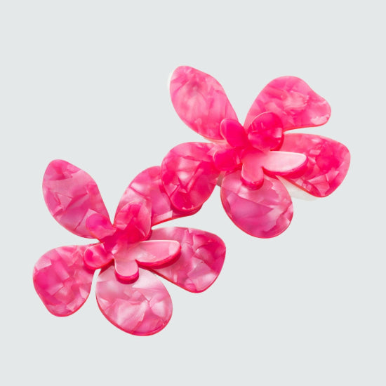 Large flower-shaped stud earrings in vibrant hot pink, featuring bold, detailed petals with a glossy finish.