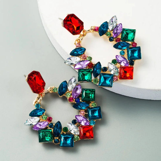 Colorful gemstone hoop earrings on a light gray background